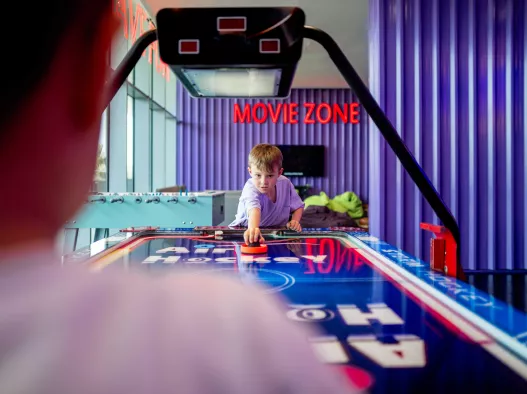 Kids playing air hockey in Ezone Centara Mirage Beach Resort Dubai