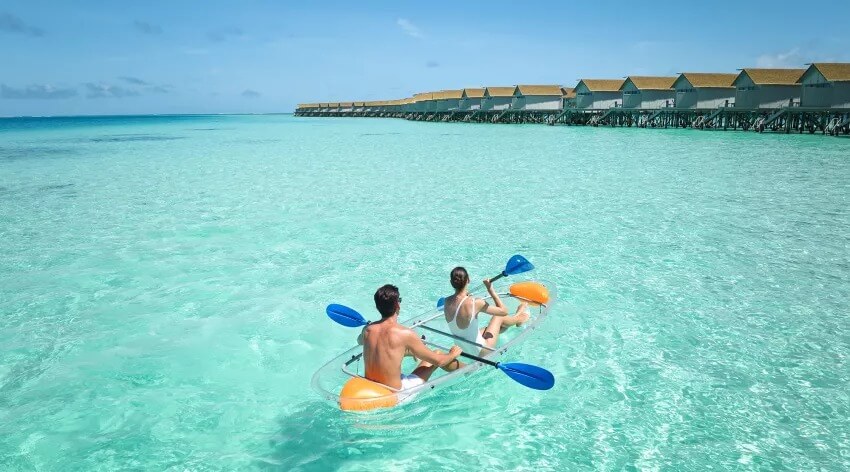 A couple paddleboarding at Centara Ras Fushi Resort & Spa 