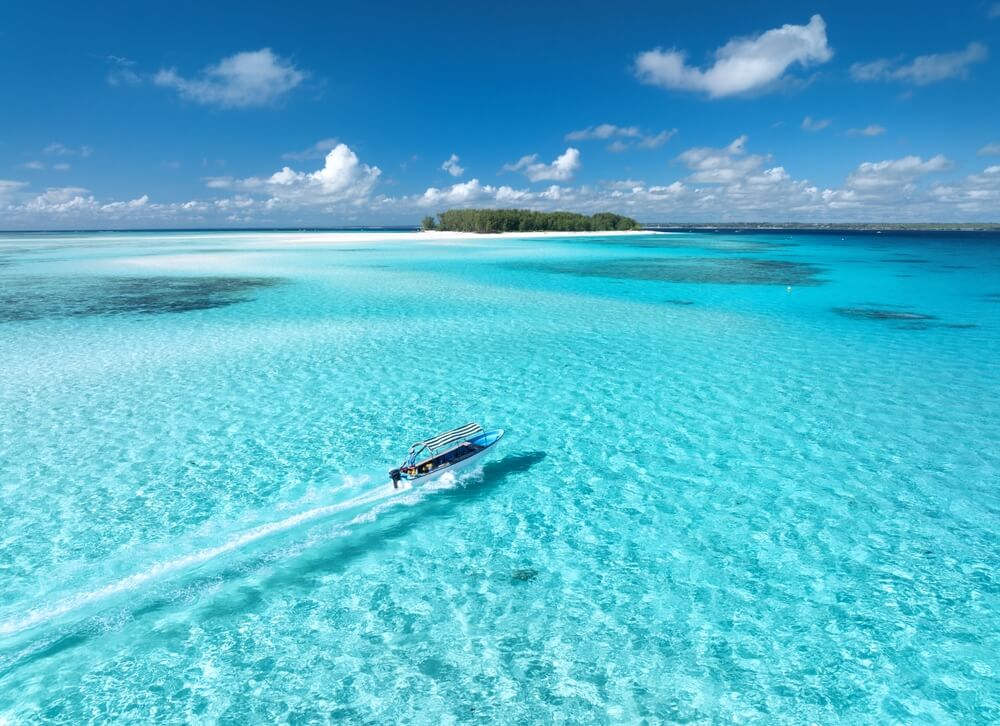 An aerial view of a boat zooming through the Maldivian sea 