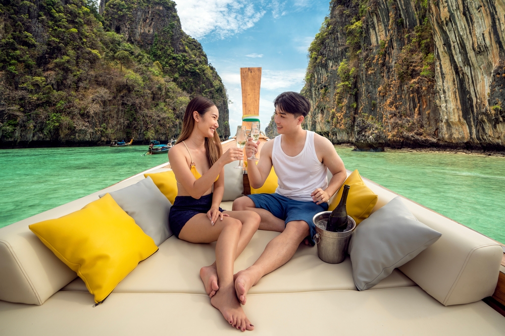 A couple island hopping during their honeymoon in Phuket on a long-tail boat
